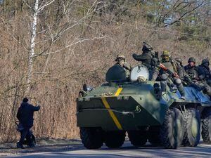 A man pushes a pram as he waves to Ukrainian soldiers on an armoured personnel carrier passing by in the Vyshgorod region close to Kyiv, Ukraine (30636483)