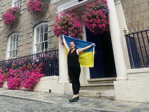 St Peter Port douzenier Evita Bormane with a Ukrainian flag which is being flown above the parish's constables office to mark 32 years of the country's independence. (32458660)