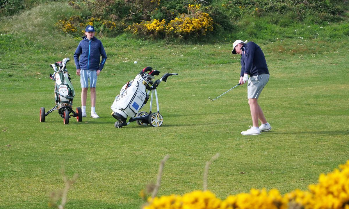 Rory McKenna hits an approach shot watched by his brother Conor. (32074421)
