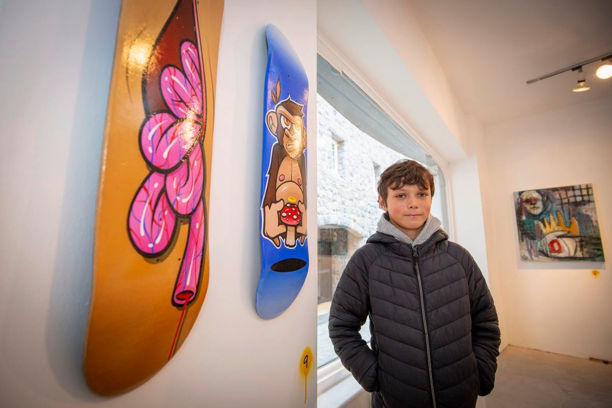 Theo Hollyer-Hill, 12, next to skateboard art that he likes in the exhibition Transformation – The Beginning of an Artistic Journey, a street art exhibition in Mansell Street.	 (Pictures by Sophie Rabey, 30418715)