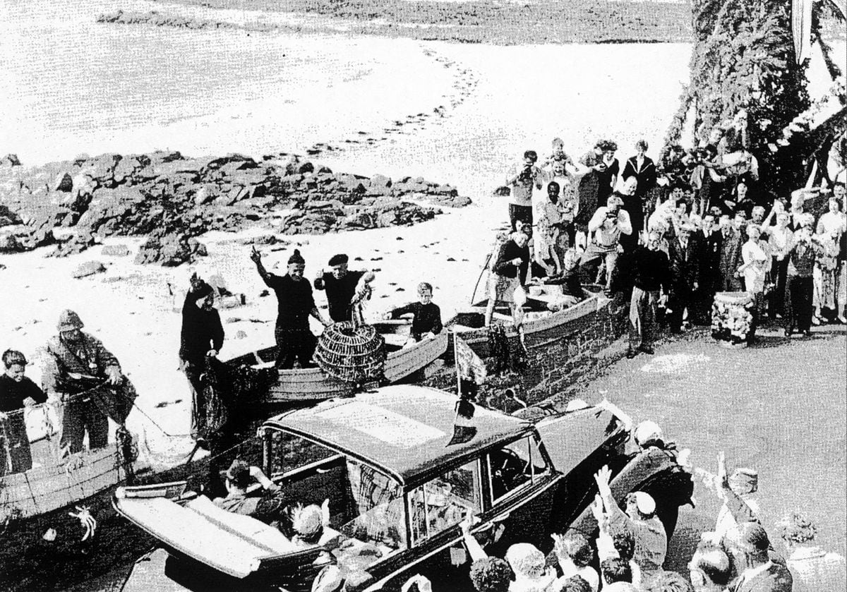 During her 1957 visit, the Queen and Prince Phillip pass through the Cobo area where locals put on a fishing-themed display. (31174217)
