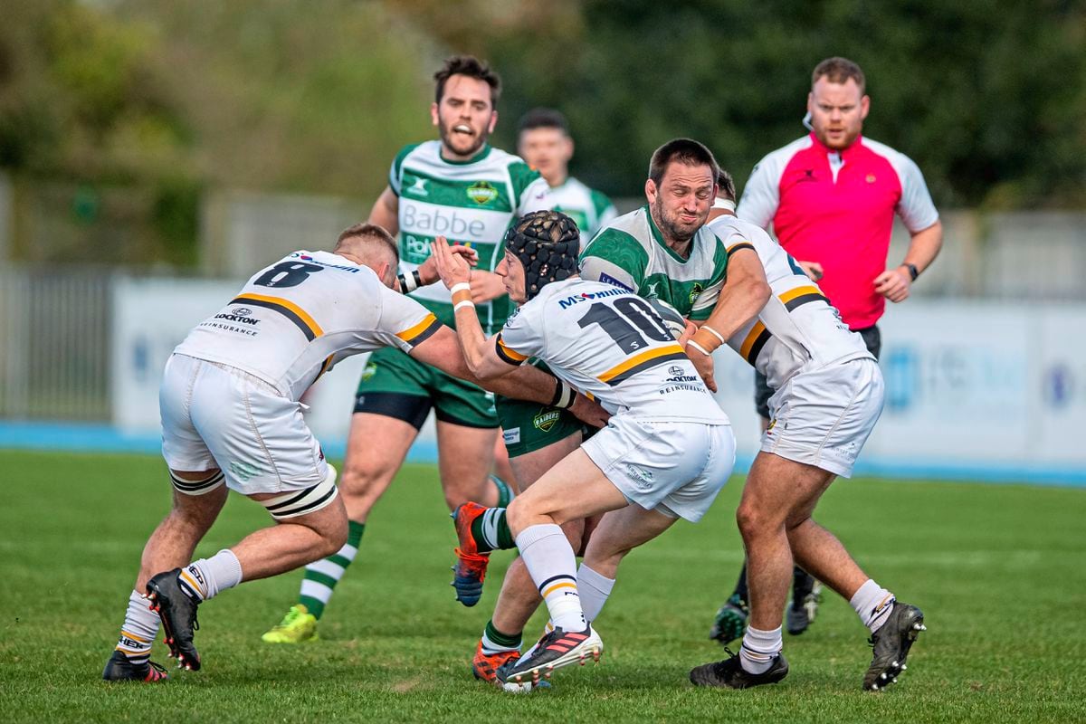 Esher's outstanding No. 10 Sam Morley is one of three tacklers converging on Raiders ball-carrier Doug Horrocks. (Picture by Martin Gray, 30680172)