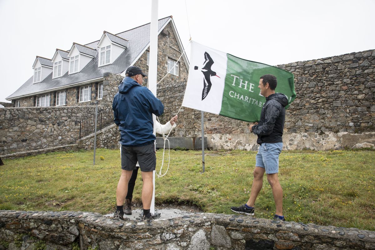 Richard Curtis, Jean Rouget and Steve Sarre (right) raising the new Lihou flag (Picture by Sophie Rabey, 25545015)