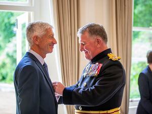 The pride is obvious in Fairtrade campaigner Steve Mauger’s smile as the Lt-Governor, Lt-General Richard Cripwell, pins the insignia of the British Empire Medal to his jacket at Saturday’s ceremony. (Pictures by Luke Le Prevost, 30944377)