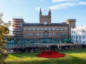 Picture By Elliot Cockett. A giant poppy has been painted on the grass at Elizabeth College. Pictured with members of the school's CCF. (30184154)