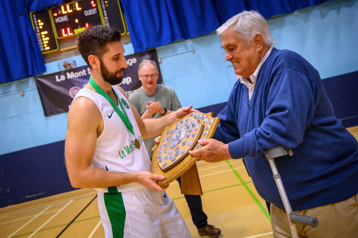 Aaron Walden receives the trophy from Ron Quinn, who captained in the first inter-insular. (Picture by Andrew Le Poidevin, 32115010)
