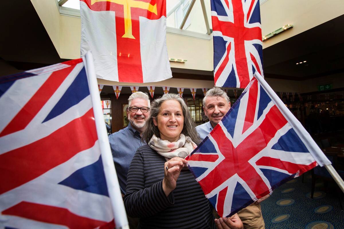 St Peter Port constable Zoe Lihou with bunting and flags to encourage people to decorate their properties for Liberation Day. She is pictured at Rocquettes Hotel with operations manager Calum Le Noury and Derek McNulty hotel manager. (Picture by Adrian Miller, 29515803)
