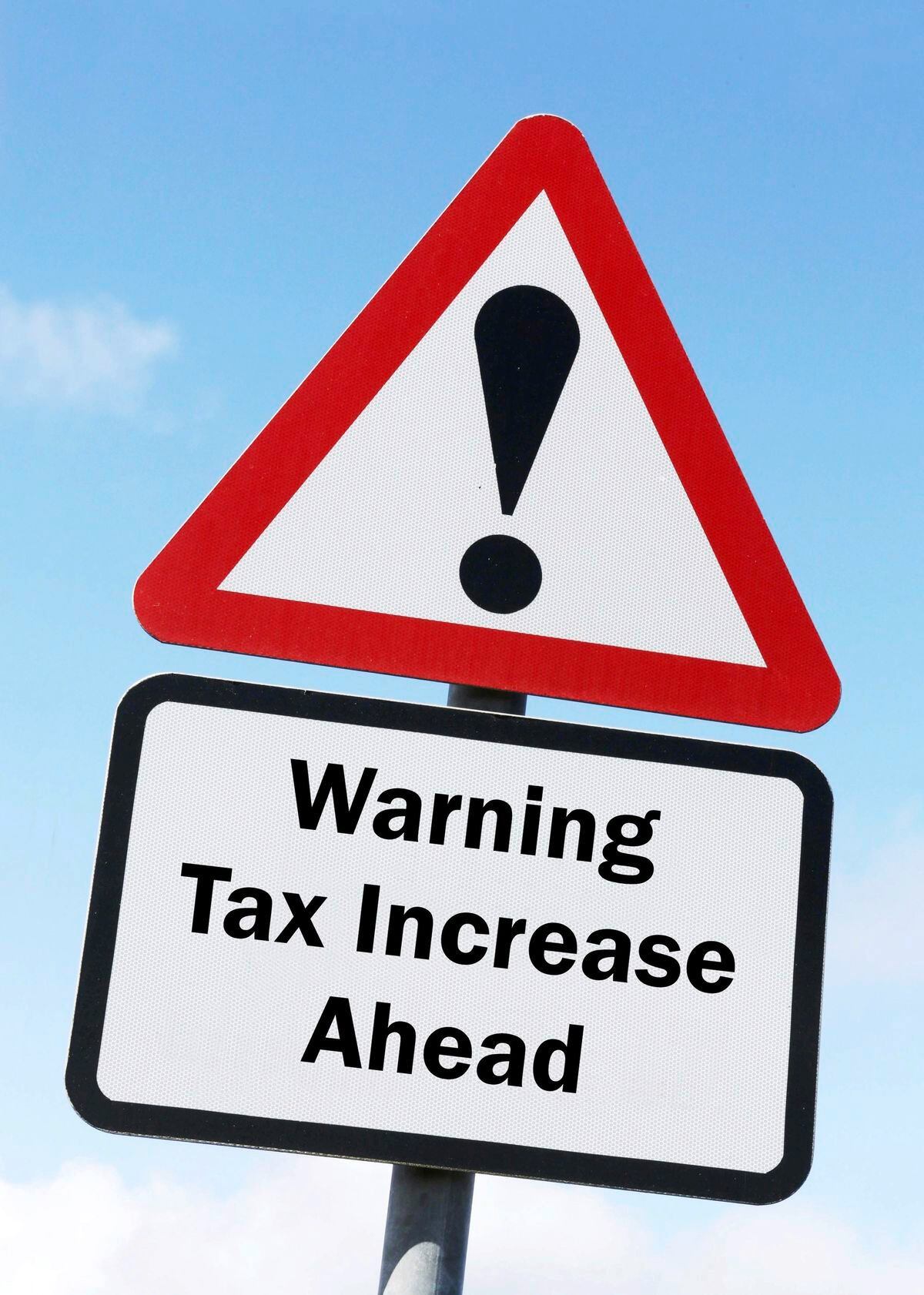 A red and white road sign depicting a warning about an increase in taxes ahead. (30416039)