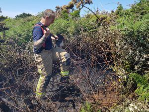 Guernsey Fire & Rescue Service red watch acting crew commander Alan Hamon digs down to discover the extent of the fire at Le Gouffre which had not spread to a big area. (Picture by Juliet Pouteaux, 30931238)