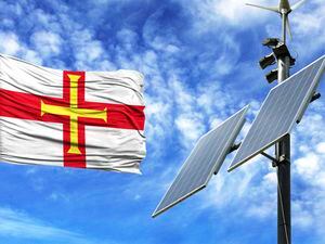 Solar panels on a background of blue sky with a flagpole and the flag of Guernsey. (32190707)