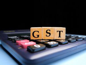 GST or Goods and Services Tax by letters on wooden beads or blocks and calculating GST with calculator. (31497691)