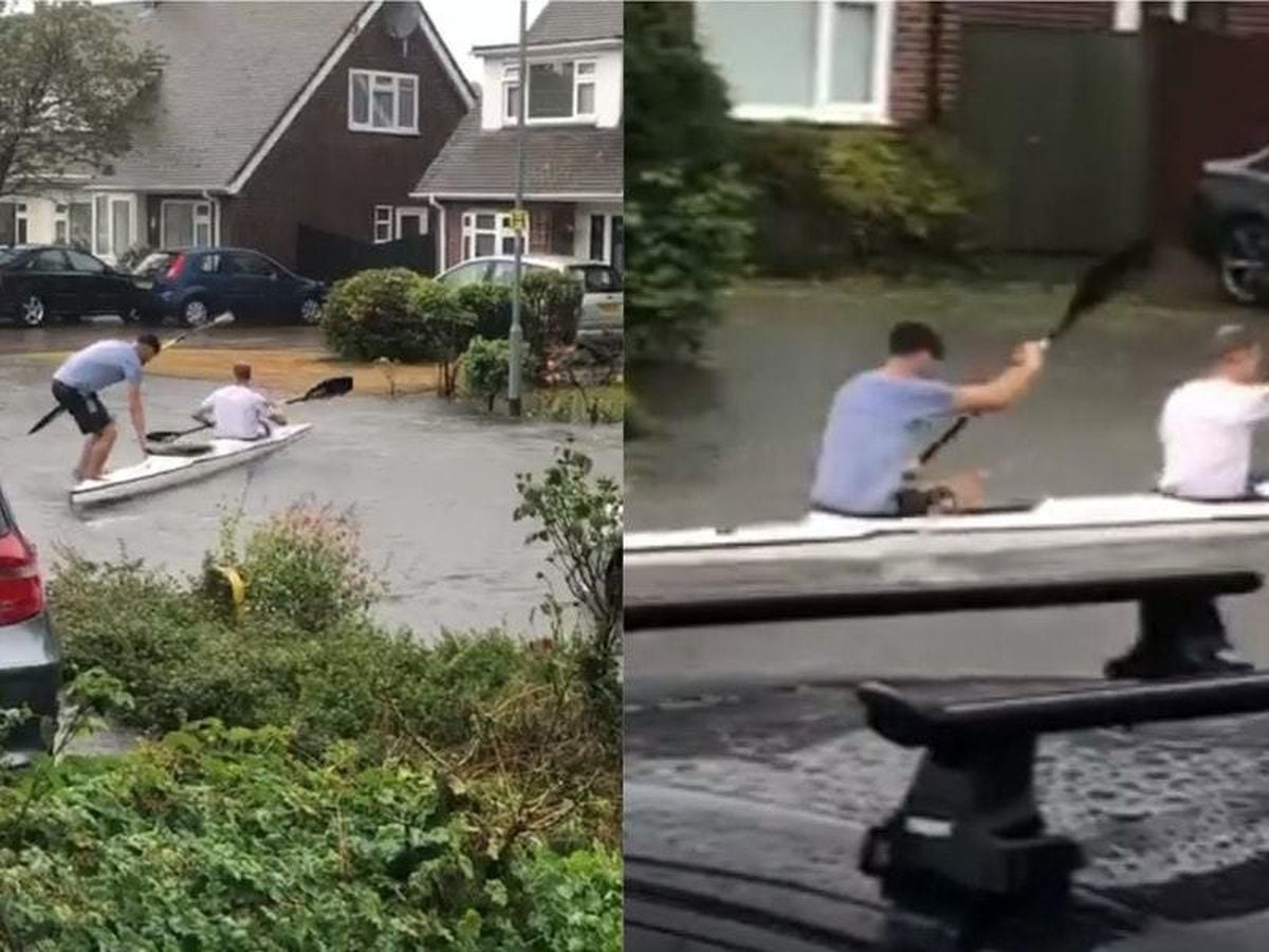 Kayakers entertain residents by paddling up and down flooded street ...