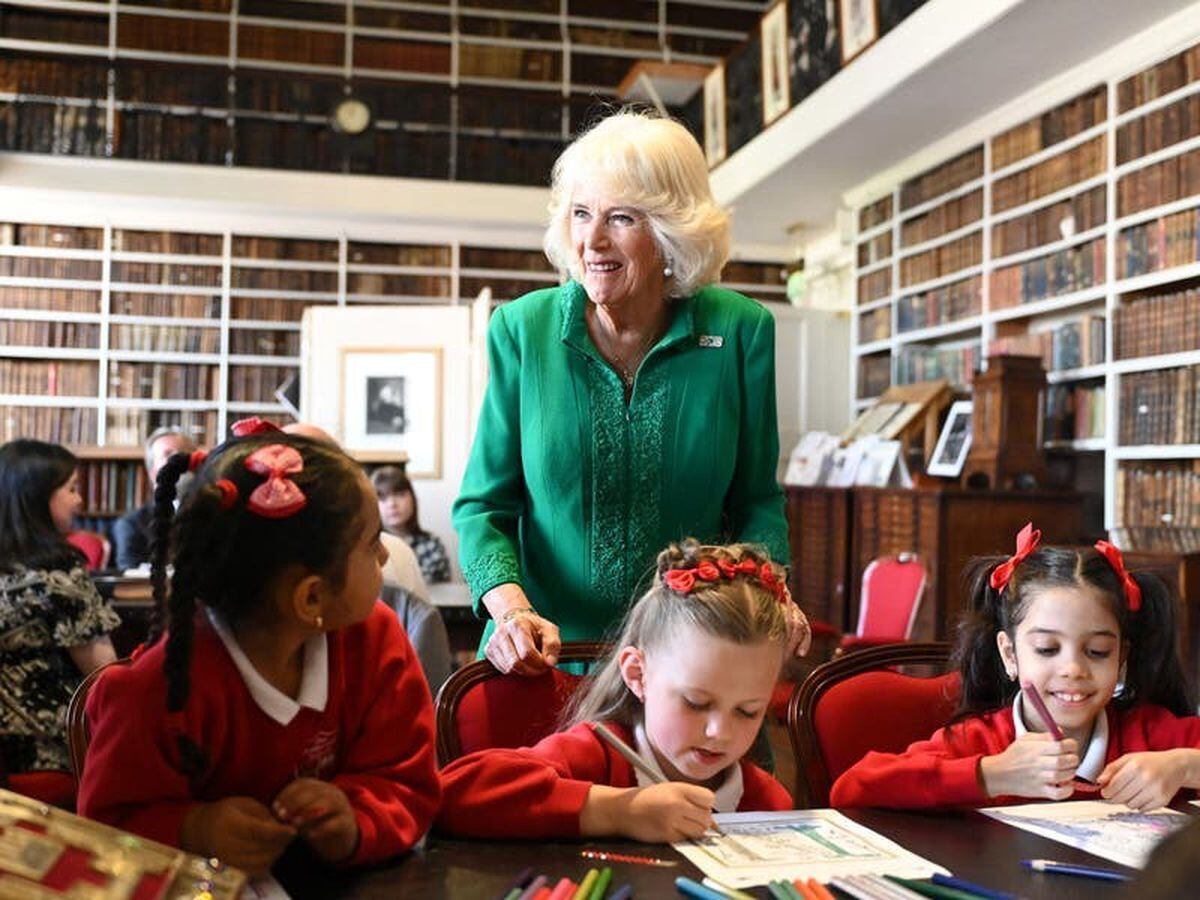 Queen Camilla meets children and volunteers at historic library