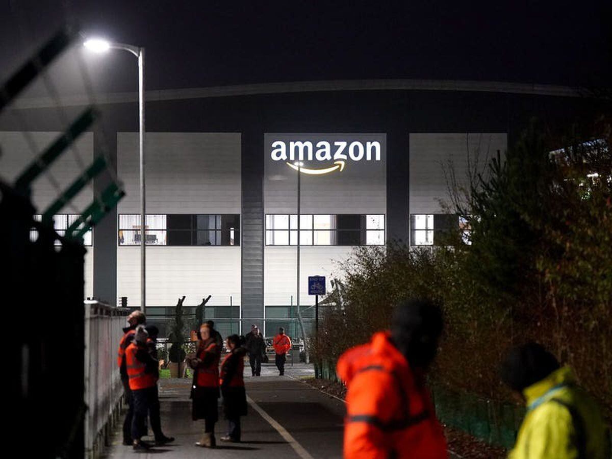 Amazon workers walk out in UK first for company’s staff in pay dispute