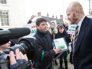 Petition organiser Mark Mauger hands it over to Deputy Gavin St Pier before the 'paise and review' debate in February 2020. (29616308)