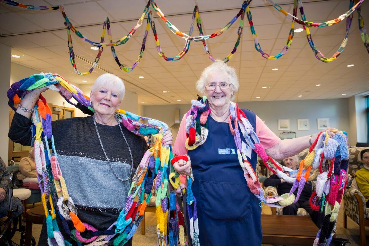 Guernsey Voluntary Service members Maureen Wright and Jill Domaille with the giant knitted chain, some of which is hanging from the ceiling. (Picture by Adrian Miller, 26501213)