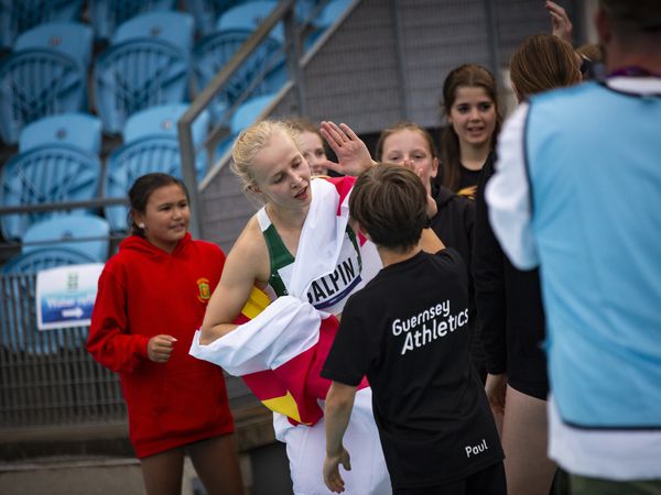 Inspiring islanders: Abi Galpin high-fiving Guernsey Athletics juniors last night at Footes Lane after her victory in the 200m. (Picture by Sophie Rabey, 32313117)