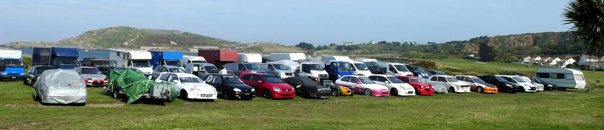 Ready for action at the weekend. Guernsey Kart and Motor Club racers and their support vans  , some containing the karts and motorbikes, wait in readiness on  Braye Common with the Victorian Fort Albert  and the Arsenal on the hillside behind them. 
Picture by David Nash, 10-09-23 (32523376)