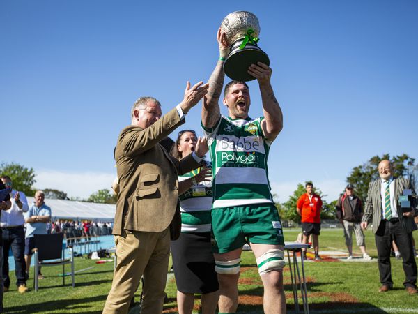 Guernsey Raiders captain Lewis Hillier shows the Siam Cup to the large home crowd after his side had beaten Jersey Reds Athletic for the second week in a row in the Spring Insure-sponsored match. (Pictures by Luke Le Prevost,  30846326)