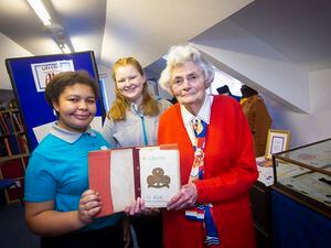 Rachel Rabey, right, who became a Brownie after being evacuated to Rochdale with her logbook from 1948 which is part of Guiding’s local archive. Pictured with her are current Guides, Keisha Duerden, left, and Millie Vaudin, both 16. (Picture by Peter Frankland, 1819001)