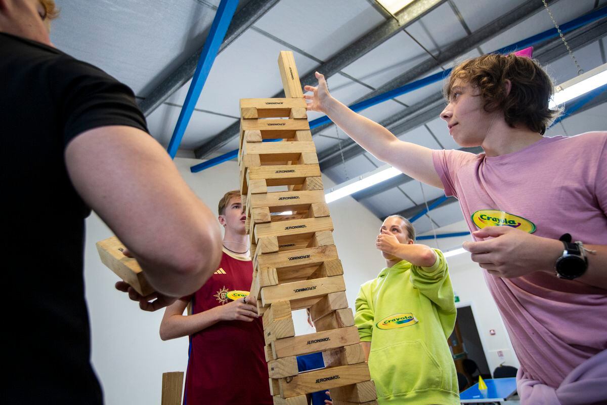 EY Sixth Form Centre Year 12 Team Building Day 2023 at Rue Maingy Scouts site. Left to right, Harry Hodgson and Libbi Legg watch closely as Flynn Jones places the last block on their tower, which stood 2.58m tall. (Picture by Luke Le Prevost, 32533044)