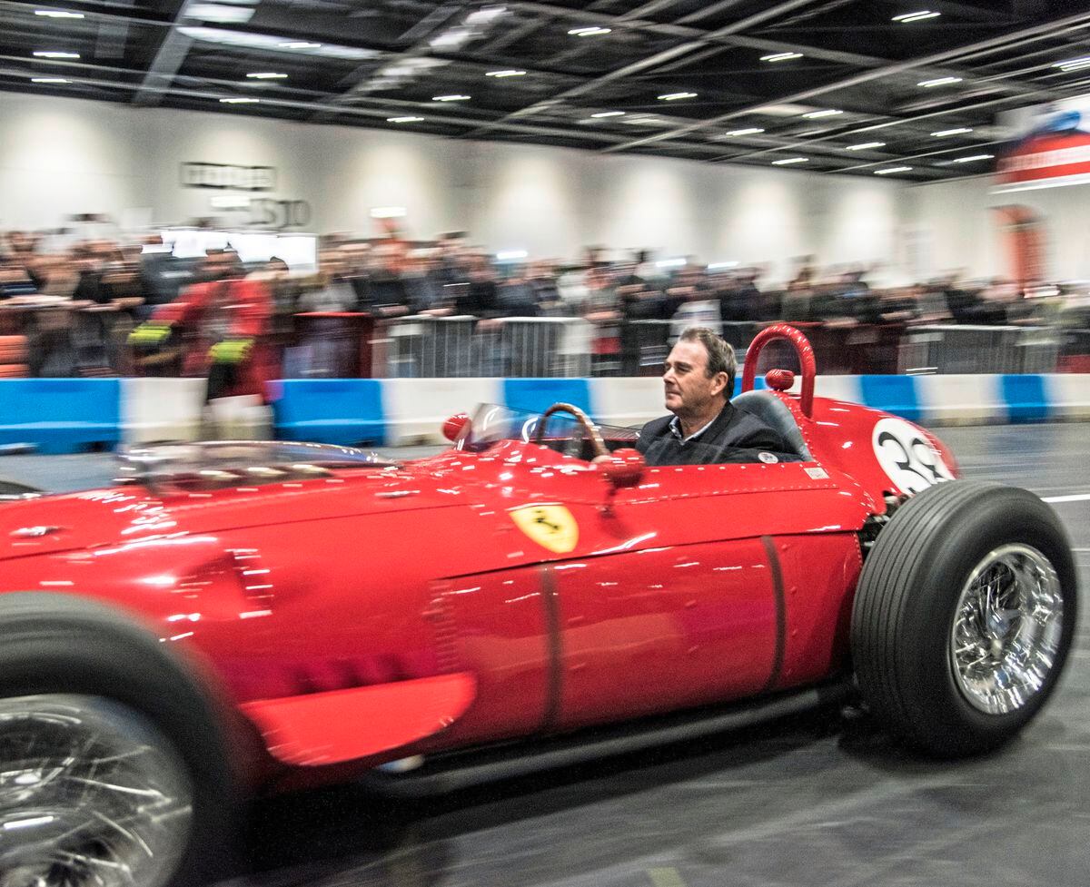 Nigel Mansell driving a scarlet Ferrari 246 Dino front-engined F1 car from the late Fifties