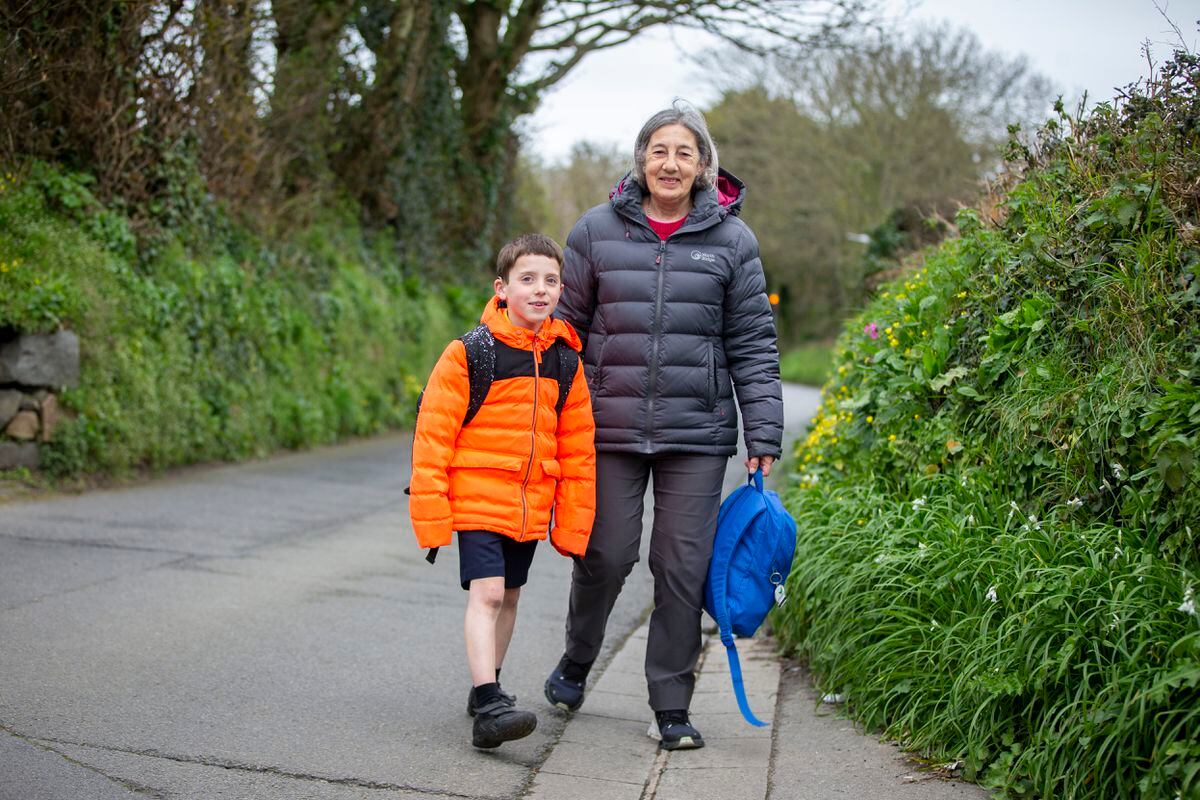 Thomas Boscher, 8, and Catherine Nicolle in Route Des Coutures which was closed around 3pm to allow students from St Martin’s primary school to walk home safely. (Picture by Luke Le Prevost, 31957265)