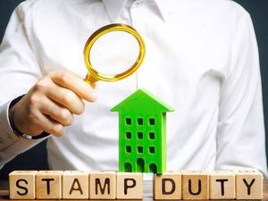 Businessman and wooden blocks with the word Stamp duty and house. Taxes assessed during the transfer of real estate between two parties. Buying housing and land. Property. Stamp Duty Land Tax/ SDLT (30390600)