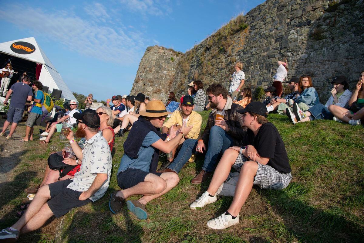 Pic supplied by Andrew Le Poidevin: 29-08-2021.
The Vale Earth Fair 2021 at Vale Castle.
The Magic Pyramid Stage benefits from the natural grass slope as festival goers chill-out to the live music. (29933246)