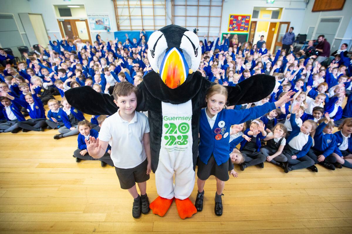 A first public appearance after being named for Jet the Puffin, the mascot of the NatWest island Games. He posed with Ted Le Tocq, 8, and Izabella Lucane, 10, in front of their fellow pupils at La Houguette Primary School. (Picture by Peter Frankland, 31924653)