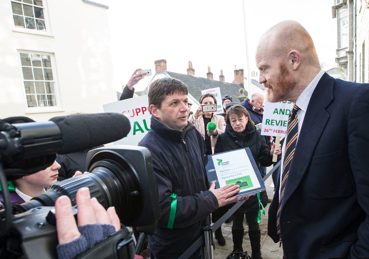 Petition organiser Mark Mauger hands it over to Deputy Gavin St Pier before the 'paise and review' debate in February 2020. (29616308)