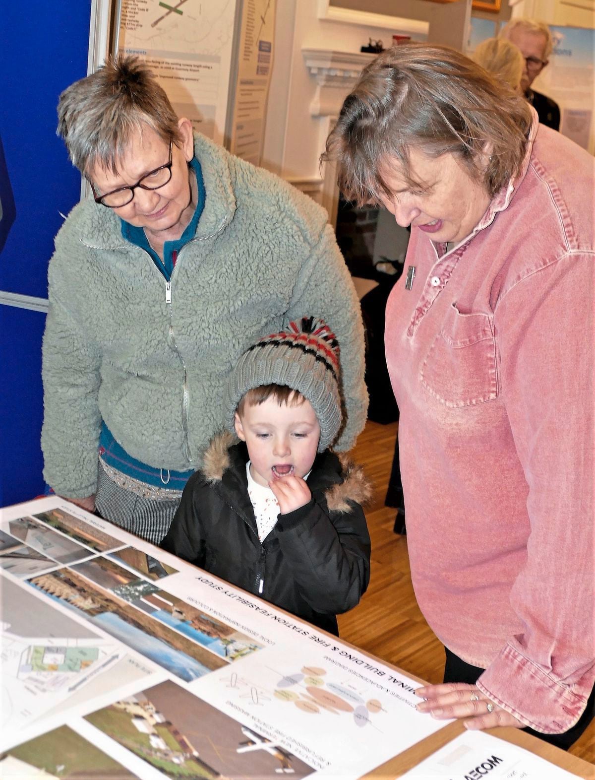 Three-year-old Brodi Pepper loves flying in the Dorniers and wants to be a pilot. He gave a thumbs-up to the plans and said he wanted to fly in a big Aurigny plane one day. He is watched by his granny Louise Bowman, left, and Alderney States member Annie Burgess, who chairs the Economic Development Committee.