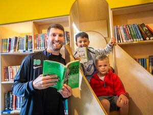 GFC star striker Ross Allen was presented with the perfect choice of book by eight-year-old Harry Piercey when he visited the Guille-Alles Library to promote its summer reading challenge, written by Manchester united and England star Marcus Rashford. Also pictured is Harry's three-year-old brother, Max. (Picture by Luke Le Prevost, 32364588)