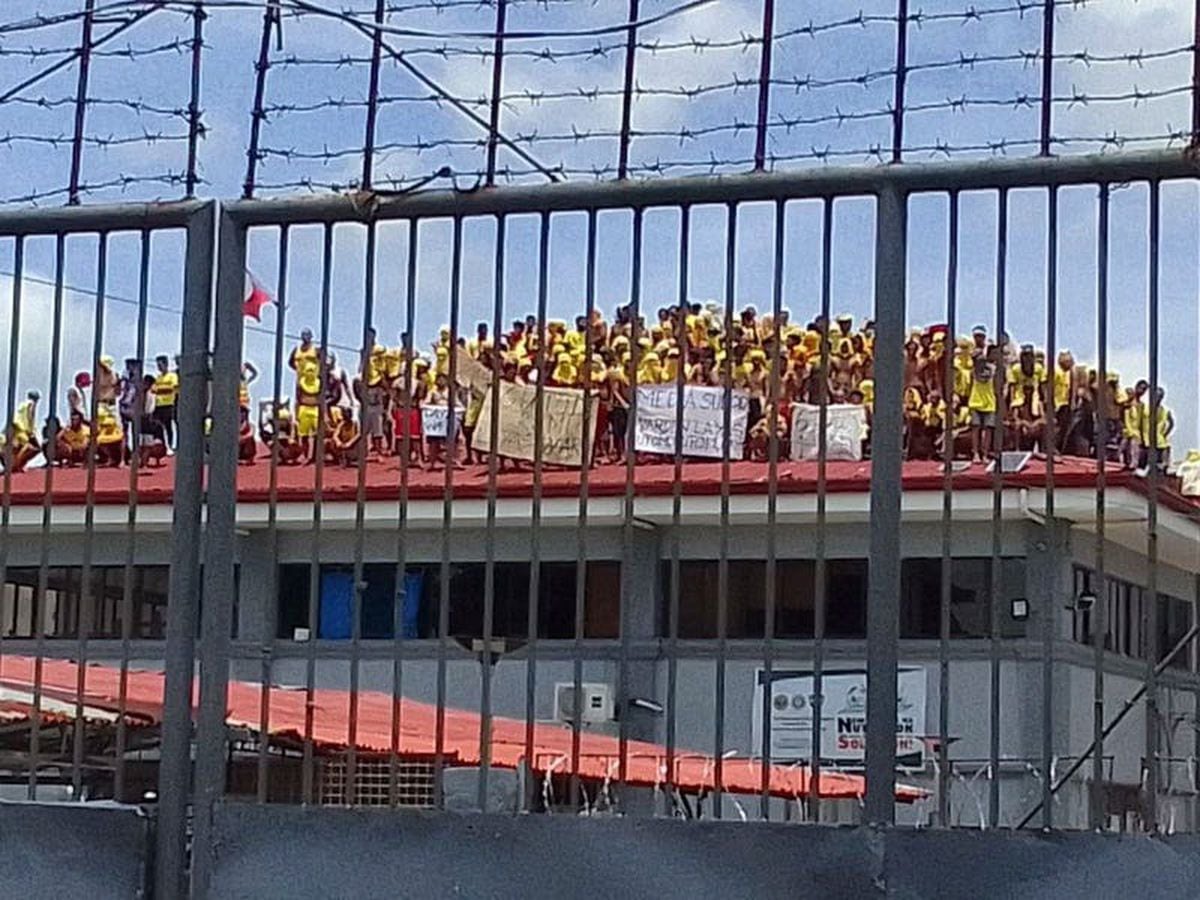 Philippines inmates protest against prison food and warden by climbing on roof