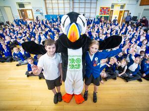 A first public appearance after being named for Jet the Puffin, the mascot of the NatWest island Games. He posed with Ted Le Tocq, 8, and Izabella Lucane, 10, in front of their fellow pupils at La Houguette Primary School. (Picture by Peter Frankland, 31924653)