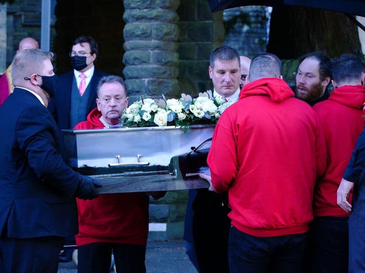 Car procession and mourners in red at funeral for boy mauled by dog